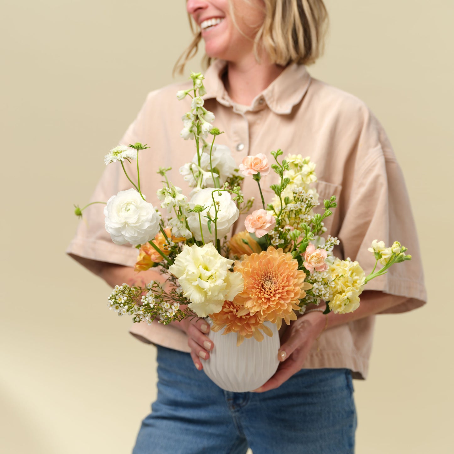 Woman holding Classic neutral + elegant flower arrangement from Native Poppy