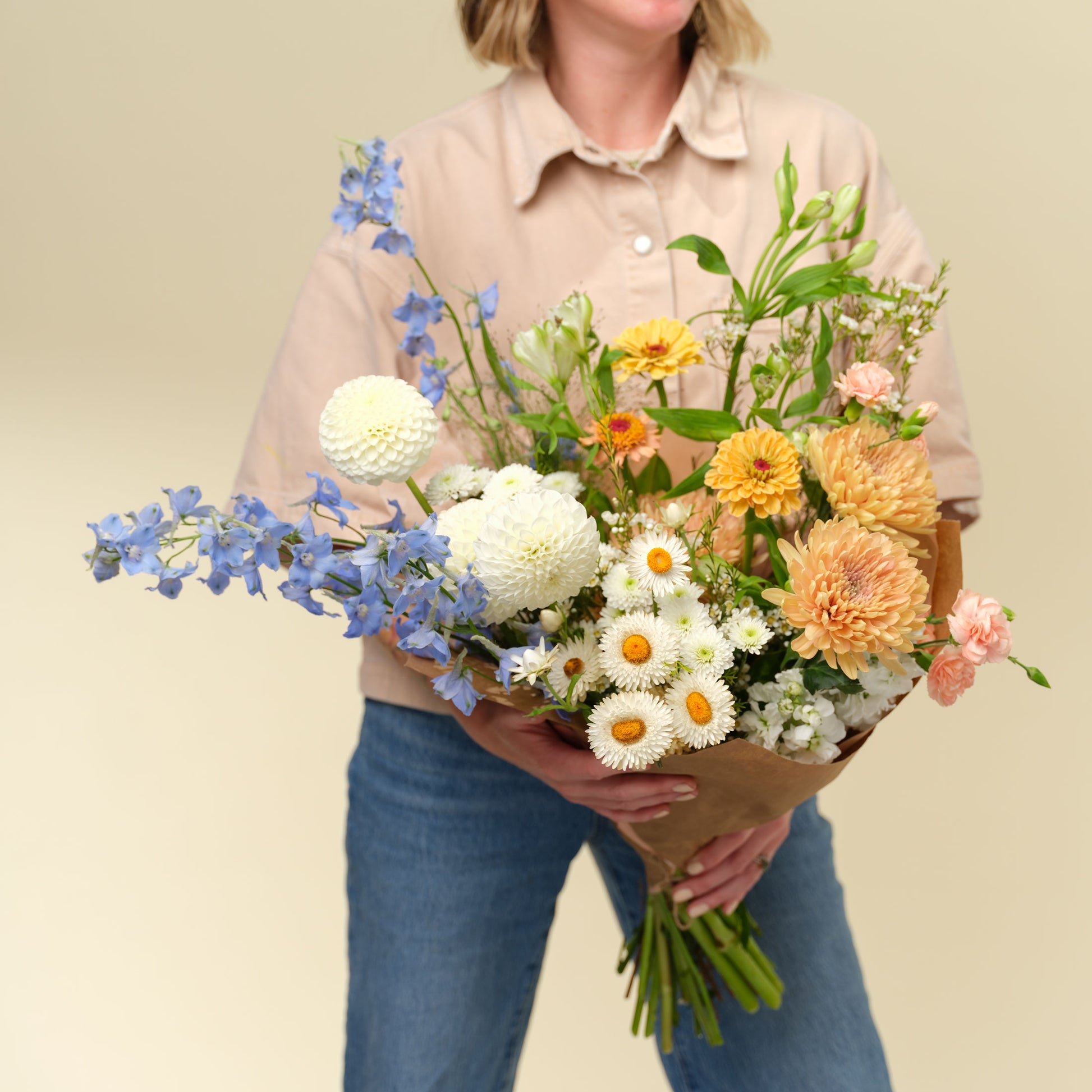 Woman holding a Extra large elegant and neutral flower wrap from Native Poppy