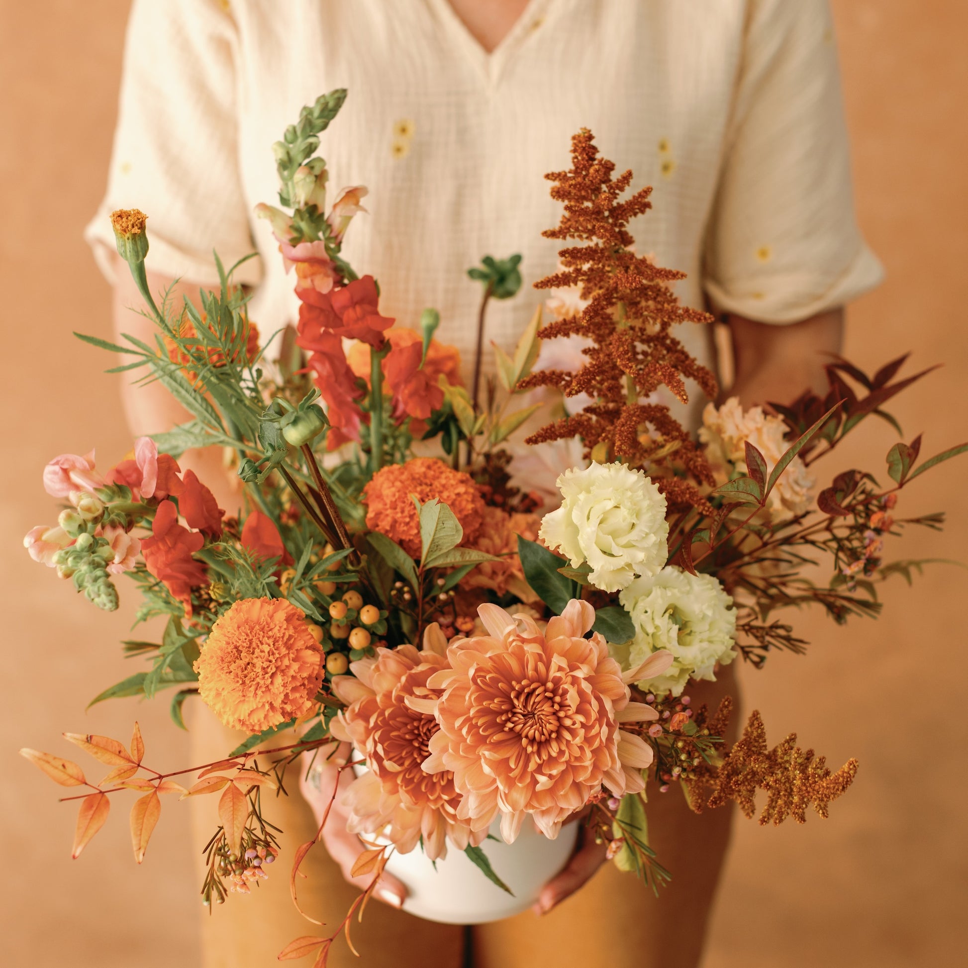 San Diego florist holding a thanksgiving flower arrangement