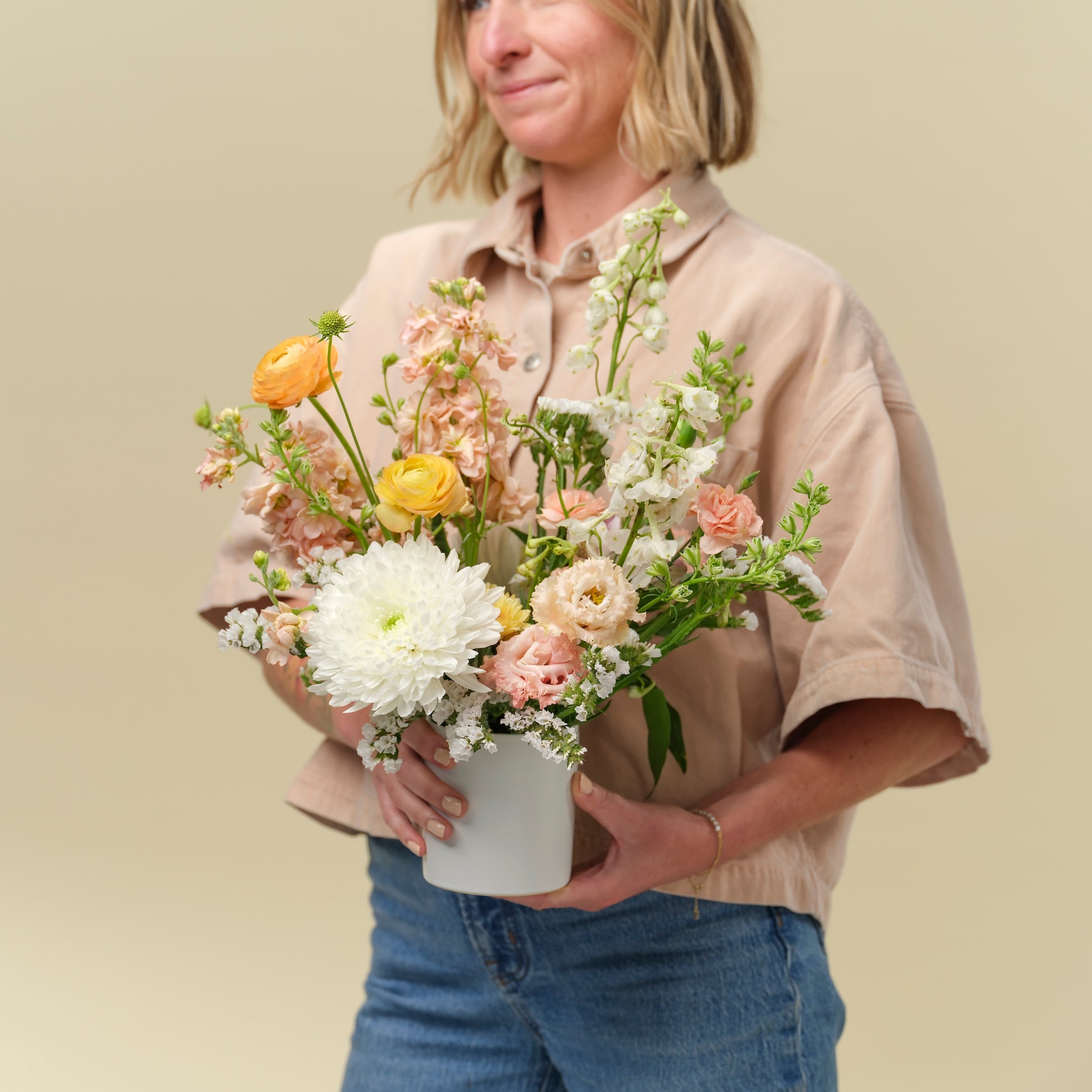 Woman holding Petite neutral flower arrangement from Native Poppy