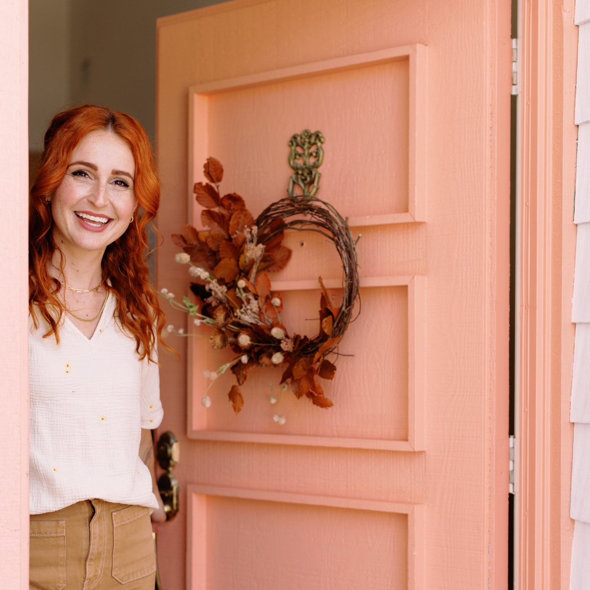 Meg Blancato at front door with fall wreath