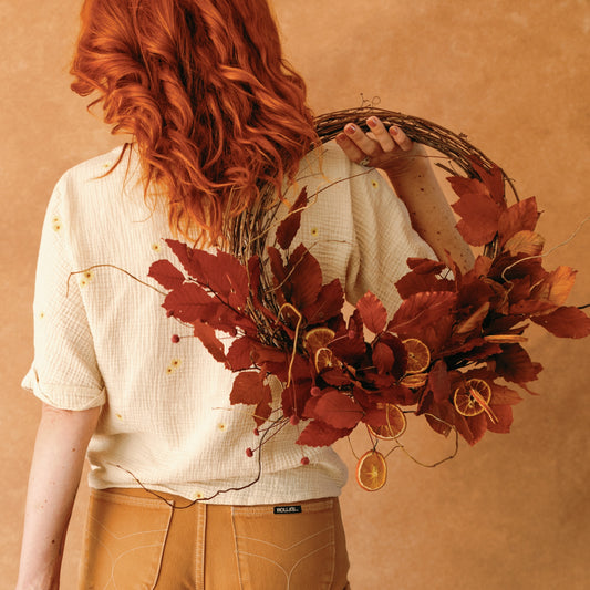 Woman holding Fall Into Citrus Wreath