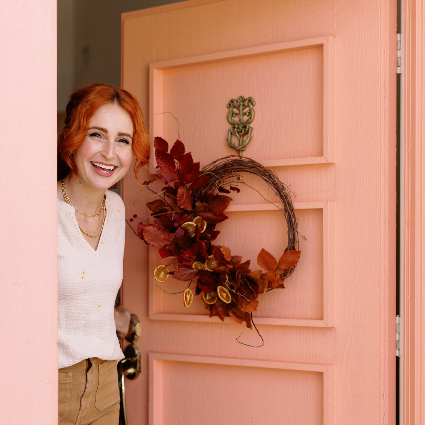 Meg Blancato opens front door with Fall Into Citrus Wreath