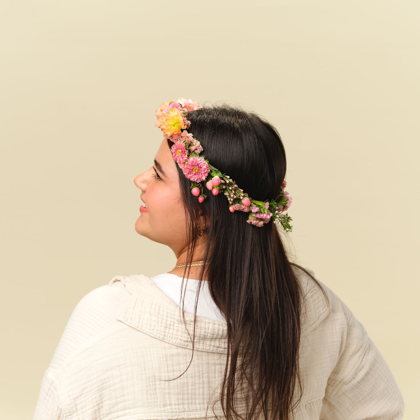 Woman wearing the Lucy Flower Crown in bright peach colors from Native Poppy