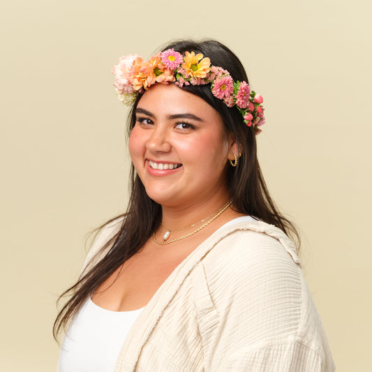 Woman wearing the Lucy Flower Crown in bright peach colors from Native Poppy