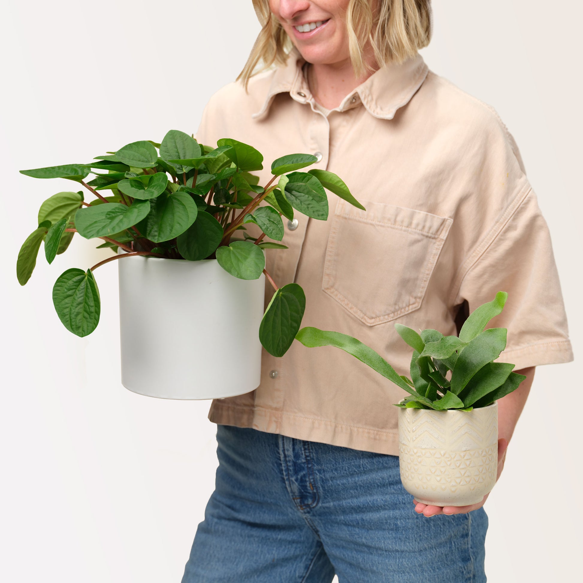 Natalie Gill holds two potted plants