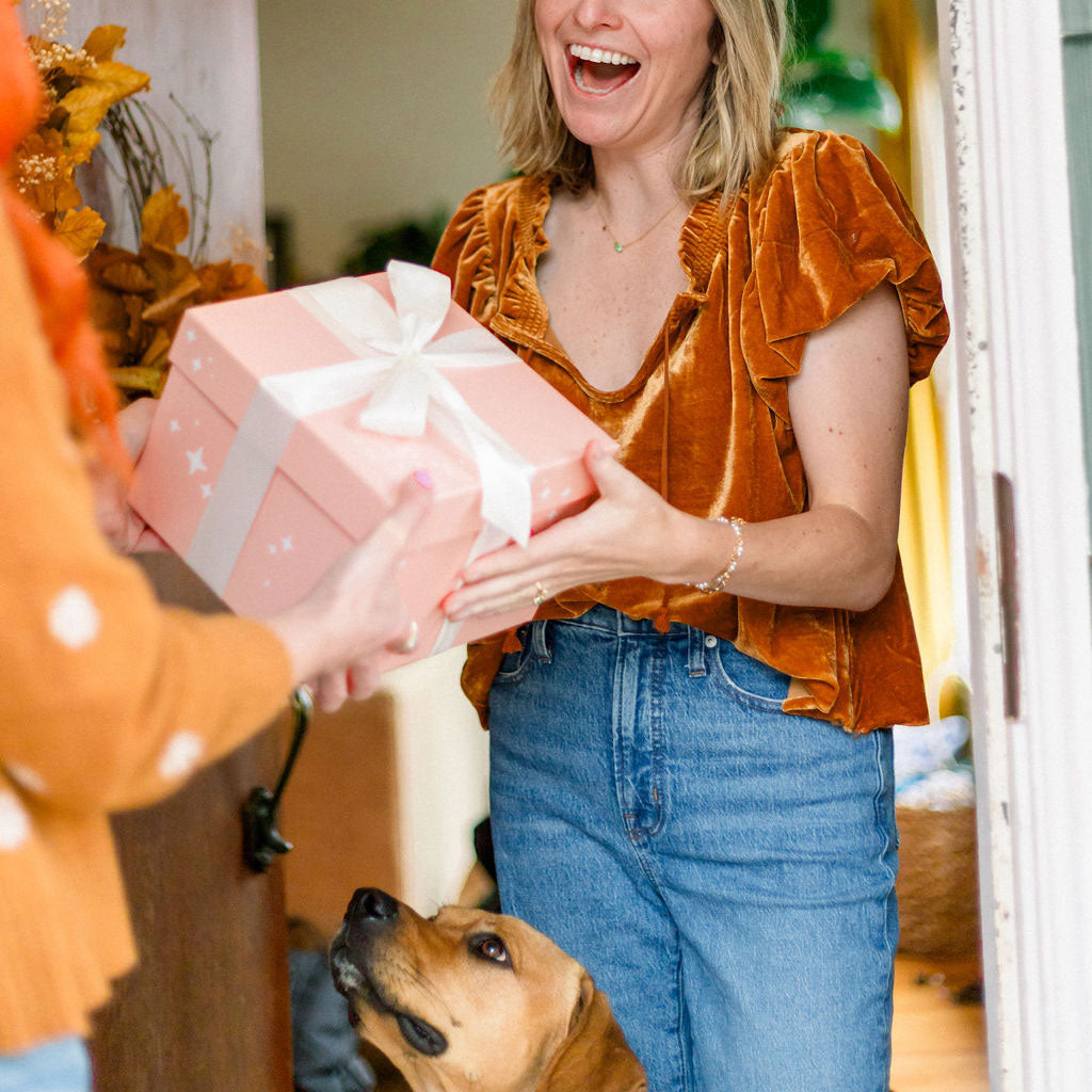 woman receiving a Native Poppy gift box at front door