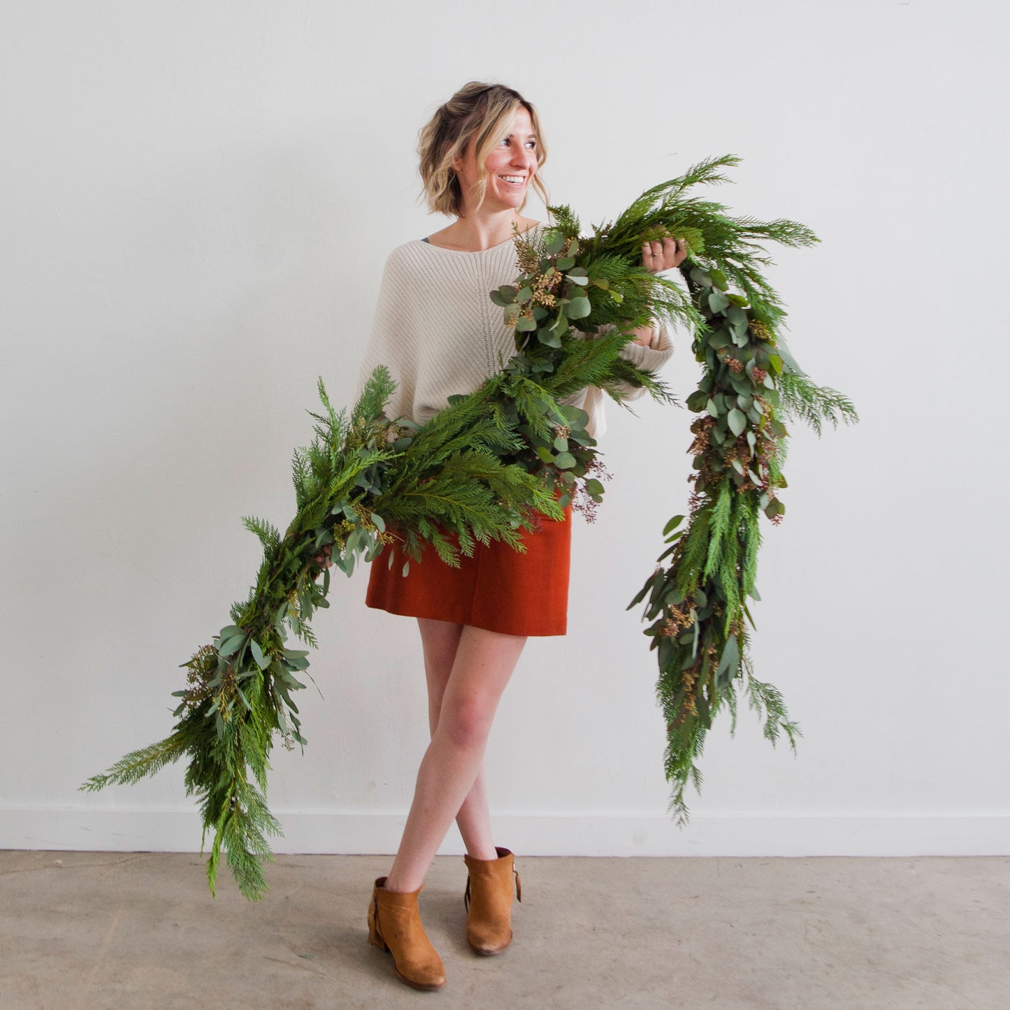 Native Poppy florist Natalie Gill holds holiday garland