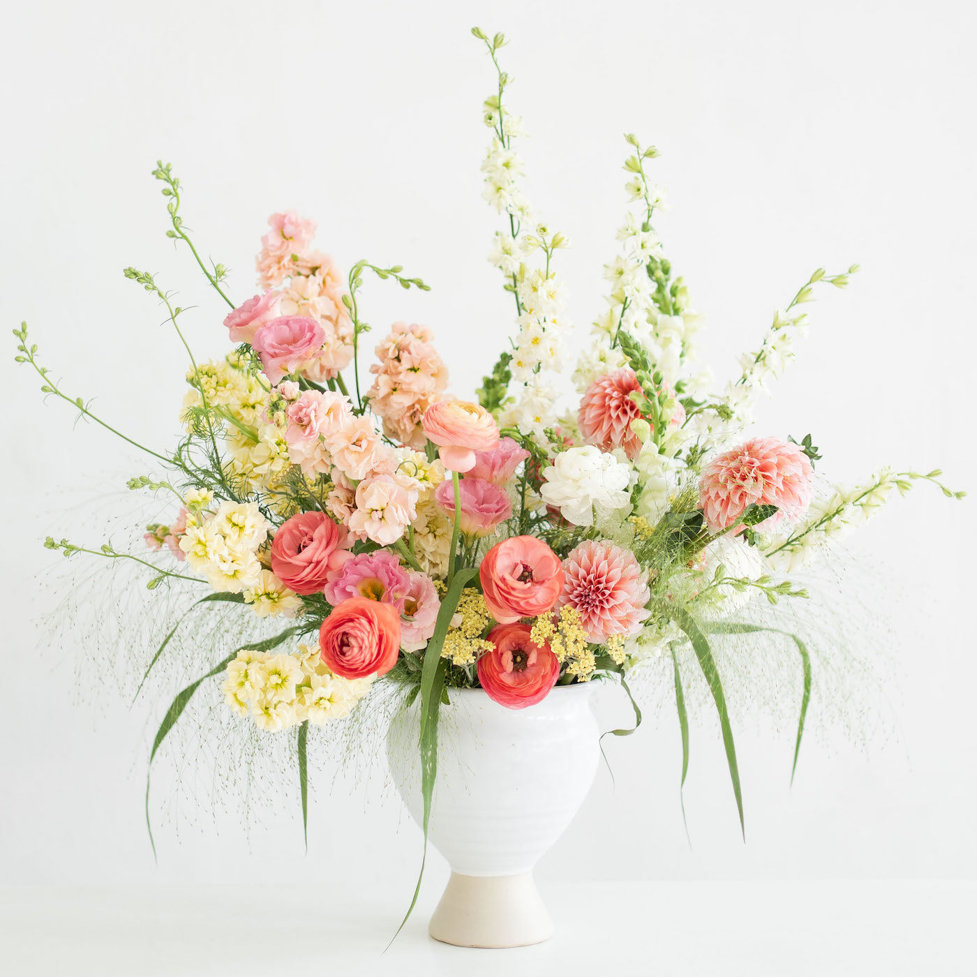 Tall Urn Flower Arrangement in peach, pink, pastel yellow, and white