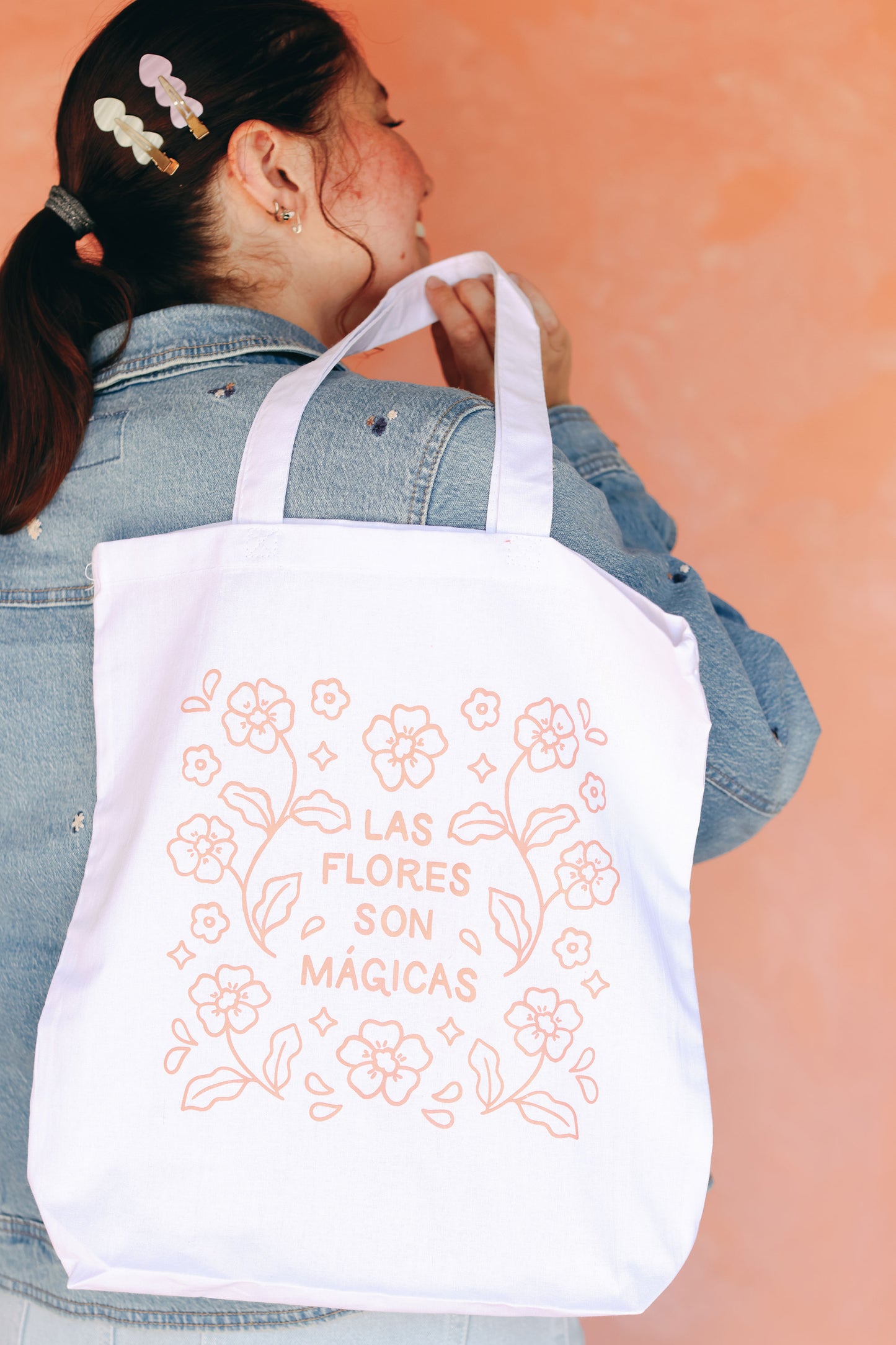 Woman holds Las Flores Son Mágicas Tote Bag from Native Poppy