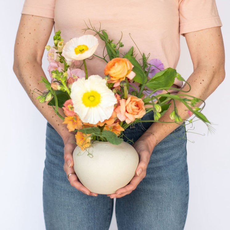 Meg Blancato holds a flower arrangement called the Garden Buddy