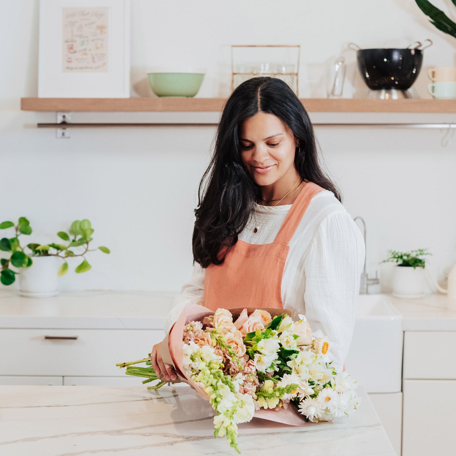 Woman holding grand neutral flower bouquet wrapped in paper