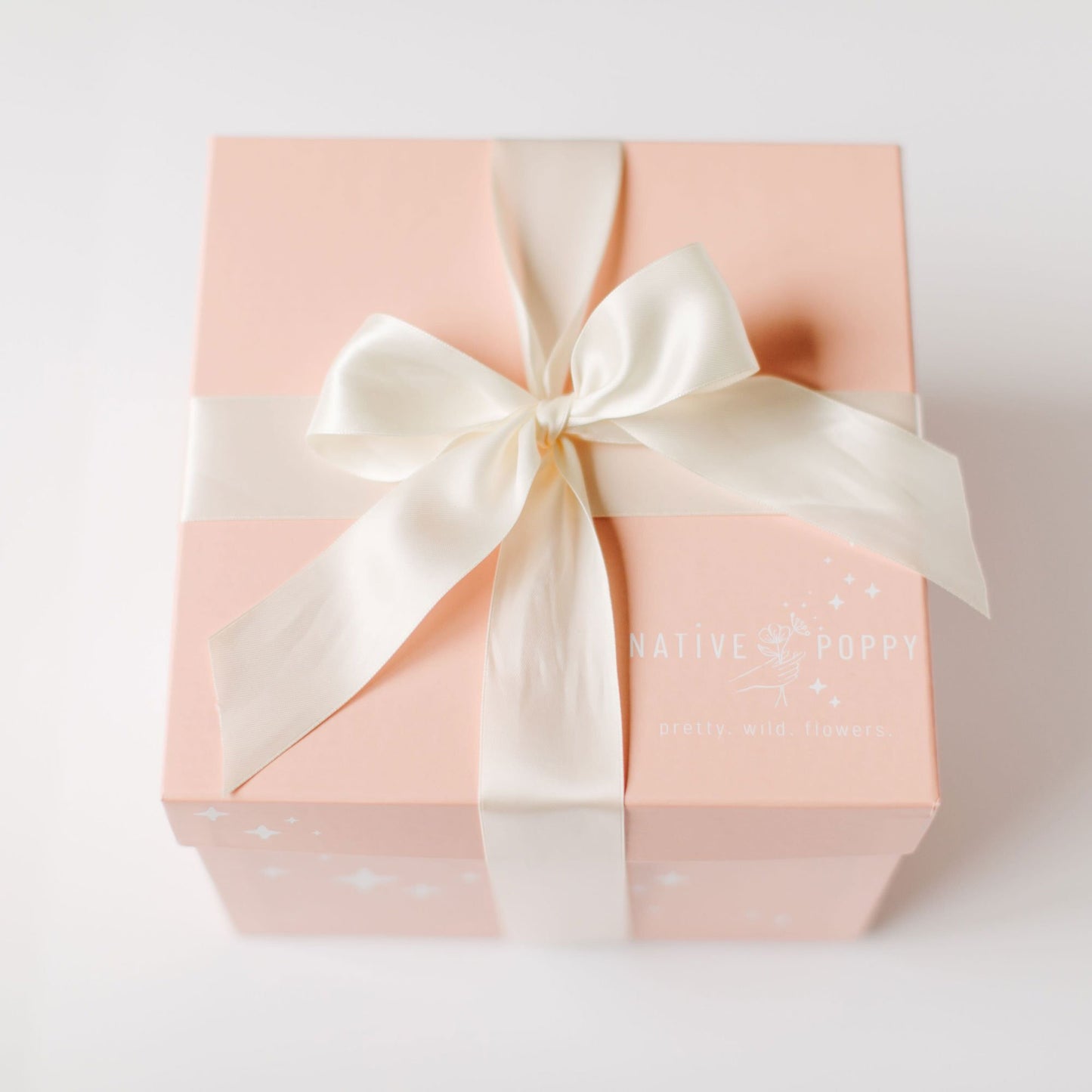 Native Poppy gift box wrapped with white satin ribbon