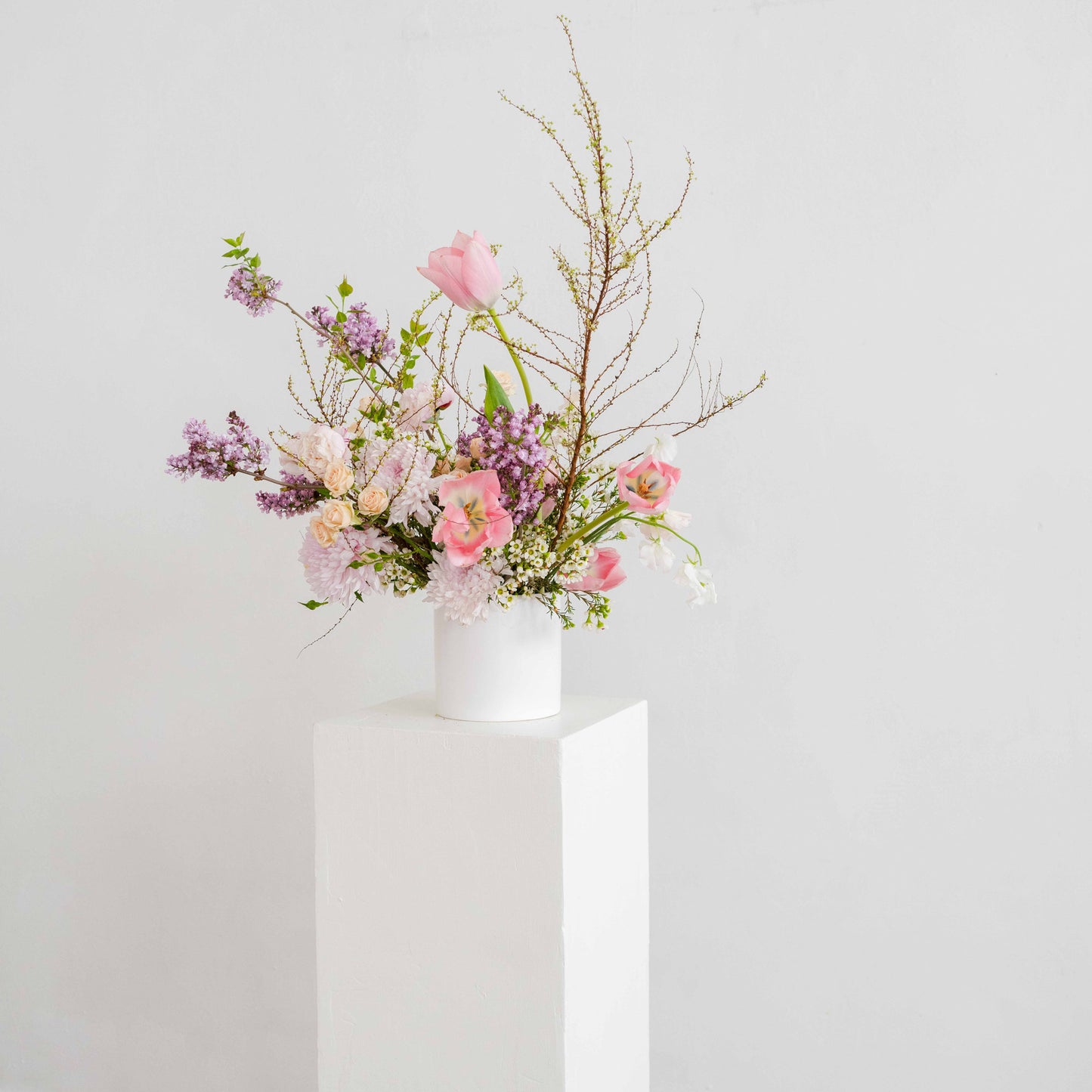 Flower arrangement on top of a white pedestal